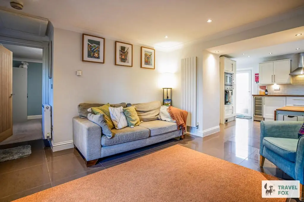 a living room with a couch and a kitchen at Daisy Cottage - Two bed country retreat with hot tub in Turriff