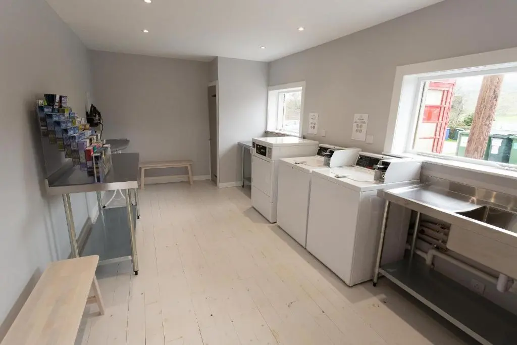 a large kitchen with white appliances and a window at The Telford Van - Beautiful, luxury static caravan in Aberlour
