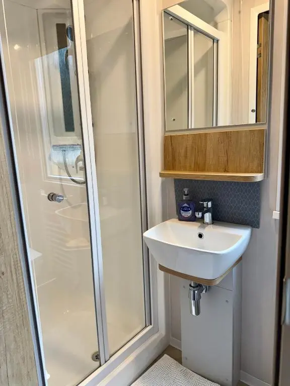 a bathroom with a shower and a sink at The Springer Van - Beautiful, luxury static caravan in Aberlour