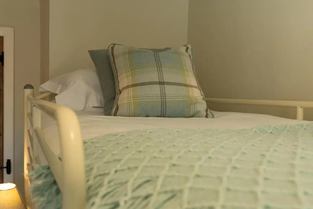 a bed with a pillow on top of it at Bridgend House B&B in Drumnadrochit