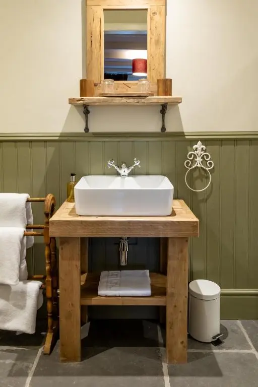 a bathroom with a white sink on a wooden table at Bridgend House B&B in Drumnadrochit