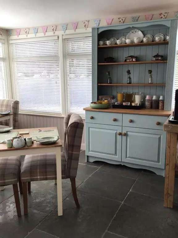a kitchen with a blue cabinet and a table at Bridgend House B&B in Drumnadrochit