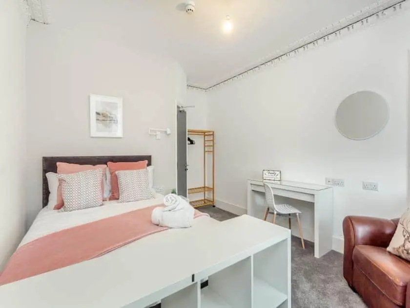 a white bedroom with a large bed and a desk at LANGLEY LODGE 7 Double Bedrooms with SMART TVs, 6 Bathrooms, Fully Equipped Kitchen, Ample PARKING, Wifi, dishwasher, Garden, GREAT CENTRAL LOCATION Ideal for BUSINESS and TRADES TEAMS For Long Stays contact Langley Cottages & Serviced Apartments in Wick