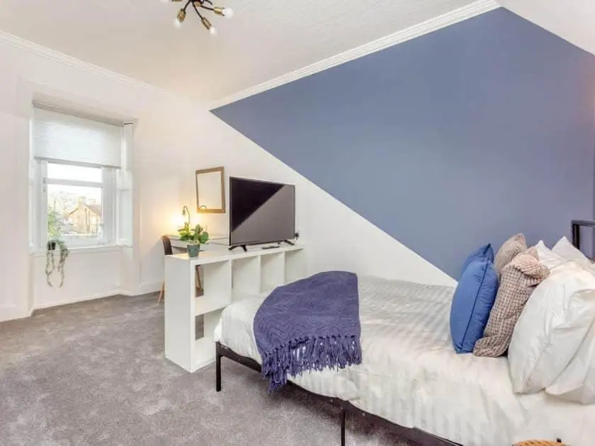 a bedroom with a bed and a tv in it at LANGLEY LODGE 7 Double Bedrooms with SMART TVs, 6 Bathrooms, Fully Equipped Kitchen, Ample PARKING, Wifi, dishwasher, Garden, GREAT CENTRAL LOCATION Ideal for BUSINESS and TRADES TEAMS For Long Stays contact Langley Cottages & Serviced Apartments in Wick