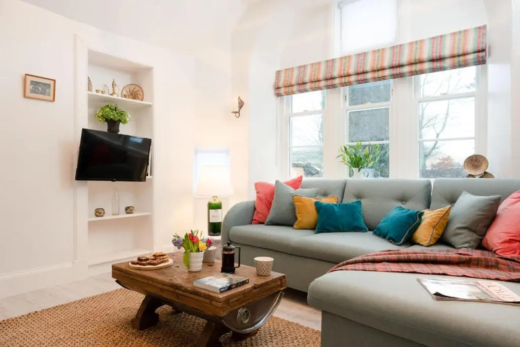 a living room with a couch and a table at West Lodge - Seasgair Lodges in Kincraig