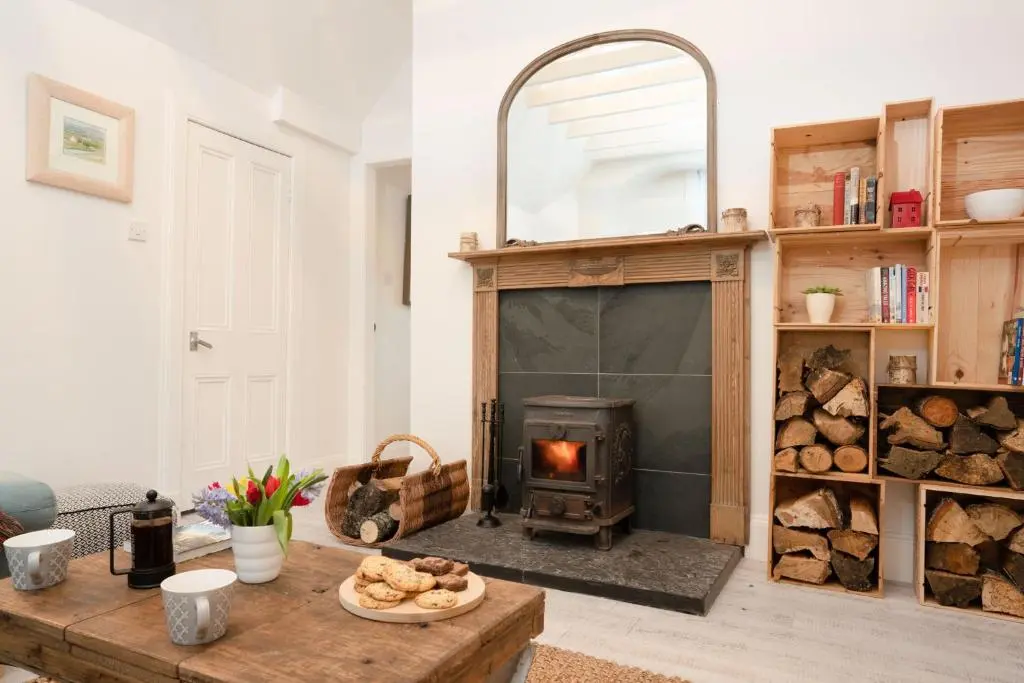 a living room with a wood stove and a table at West Lodge - Seasgair Lodges in Kincraig