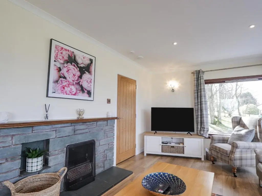 a living room with a fireplace and a tv at Fresh Fields in Dingwall