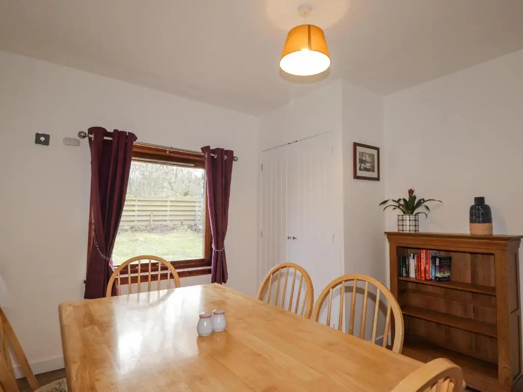 a dining room with a table and chairs and a window at Fresh Fields in Dingwall