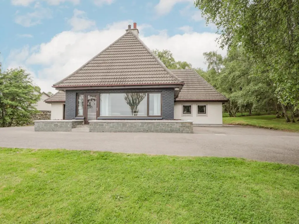 a house with a large window in a driveway at Fresh Fields in Dingwall