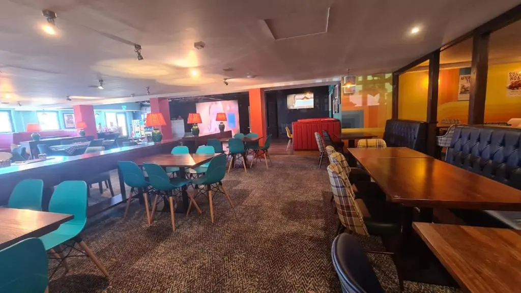 a restaurant with tables and chairs and a bar at Lyons Retreat in Lossiemouth