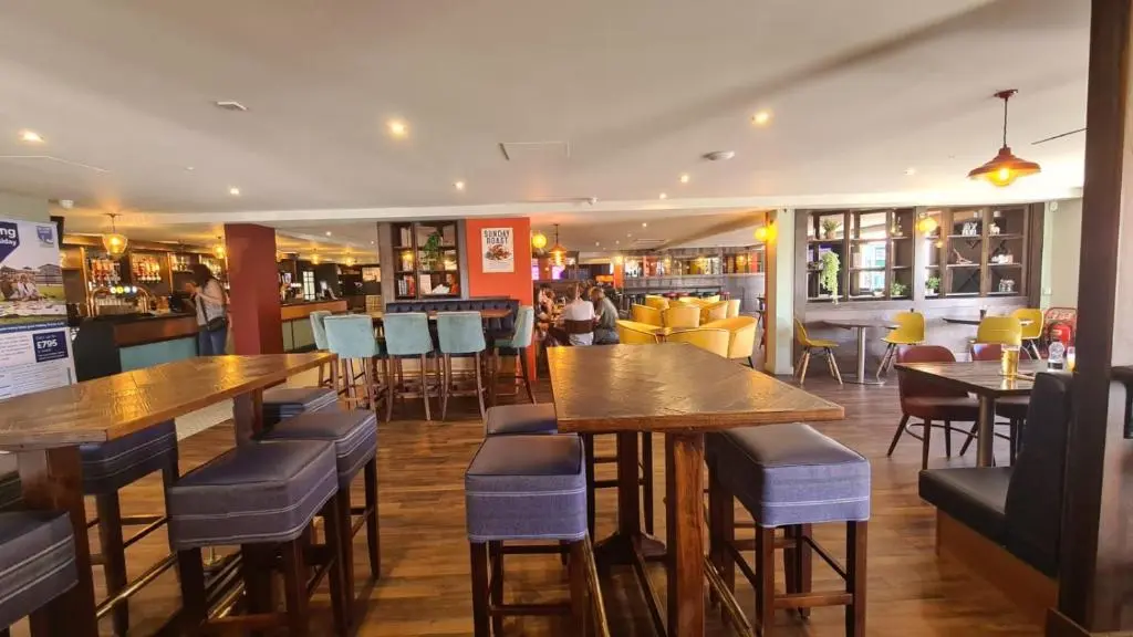 a restaurant with wooden tables and chairs and a bar at Lyons Retreat in Lossiemouth