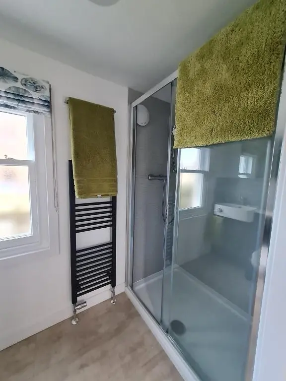 a shower with a glass door in a bathroom at Old Police Station, Portsoy in Portsoy