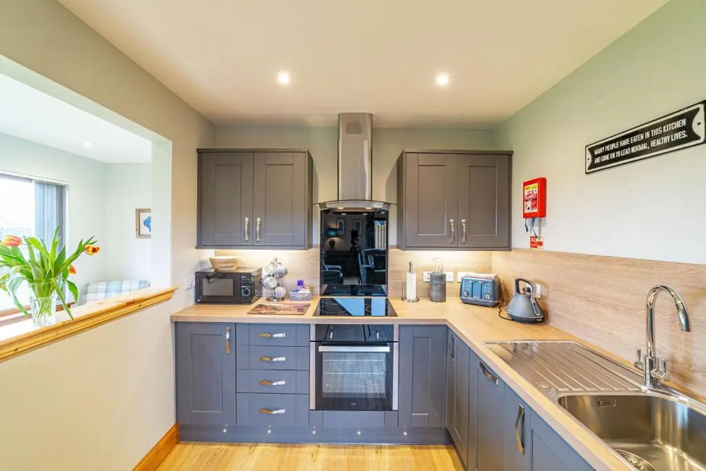 a kitchen with blue cabinets and a sink at Roe Deer Lodge with Hot Tub in Cray