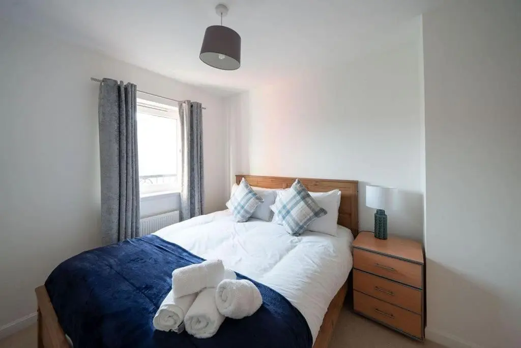 a bedroom with a bed with two towels on it at Hope House - 2 bedroom flat in Aberdeen