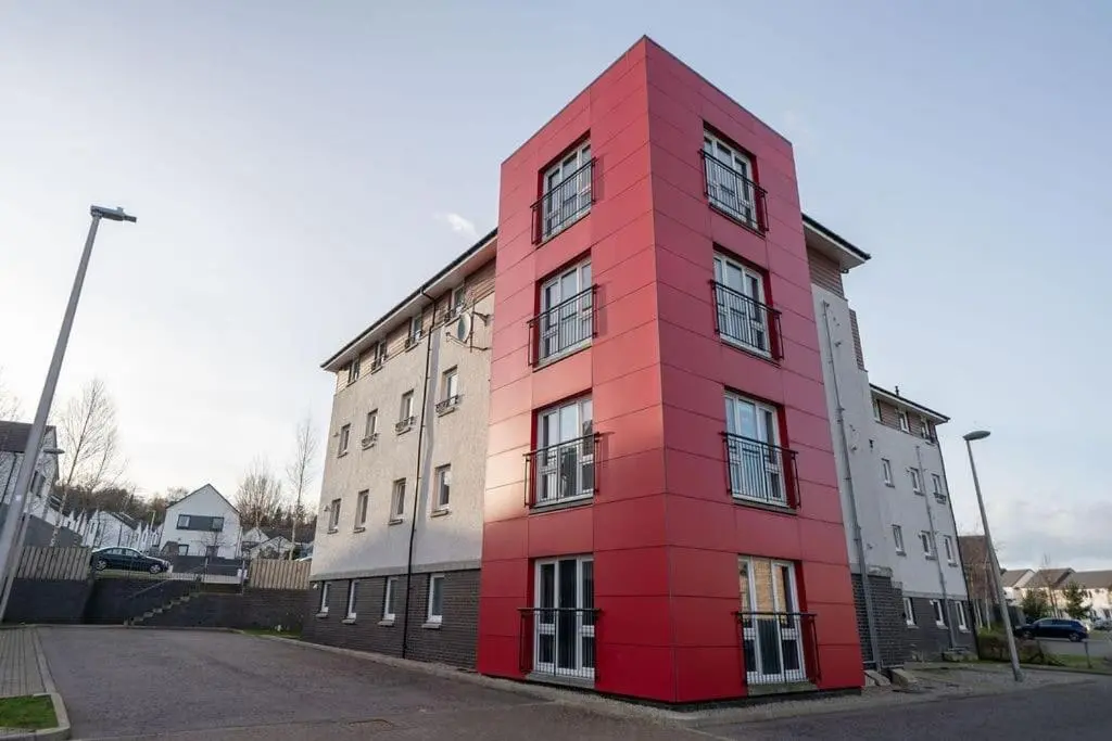a red building on the side of a street at Hope House - 2 bedroom flat in Aberdeen