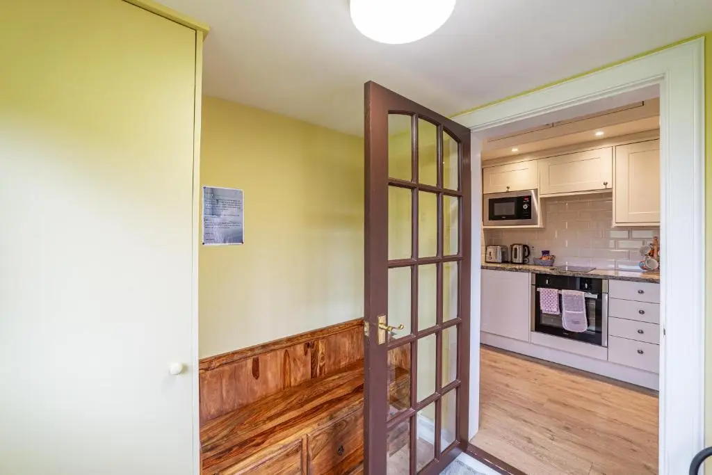 a kitchen with a door open to a kitchen with a counter at Pine Marten Lodge with Hot Tub in Cray