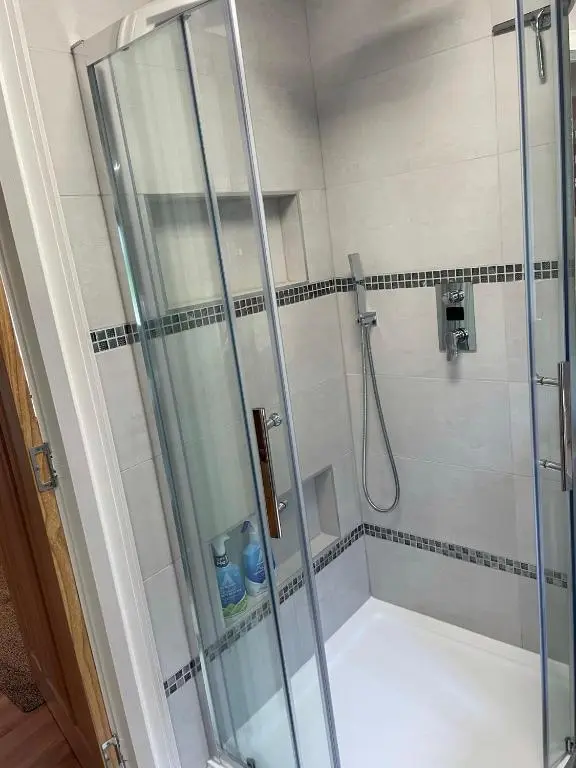 a shower with a glass door in a bathroom at The Apartment in Nairn