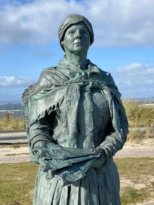 a statue of a woman standing in a field at The Apartment in Nairn