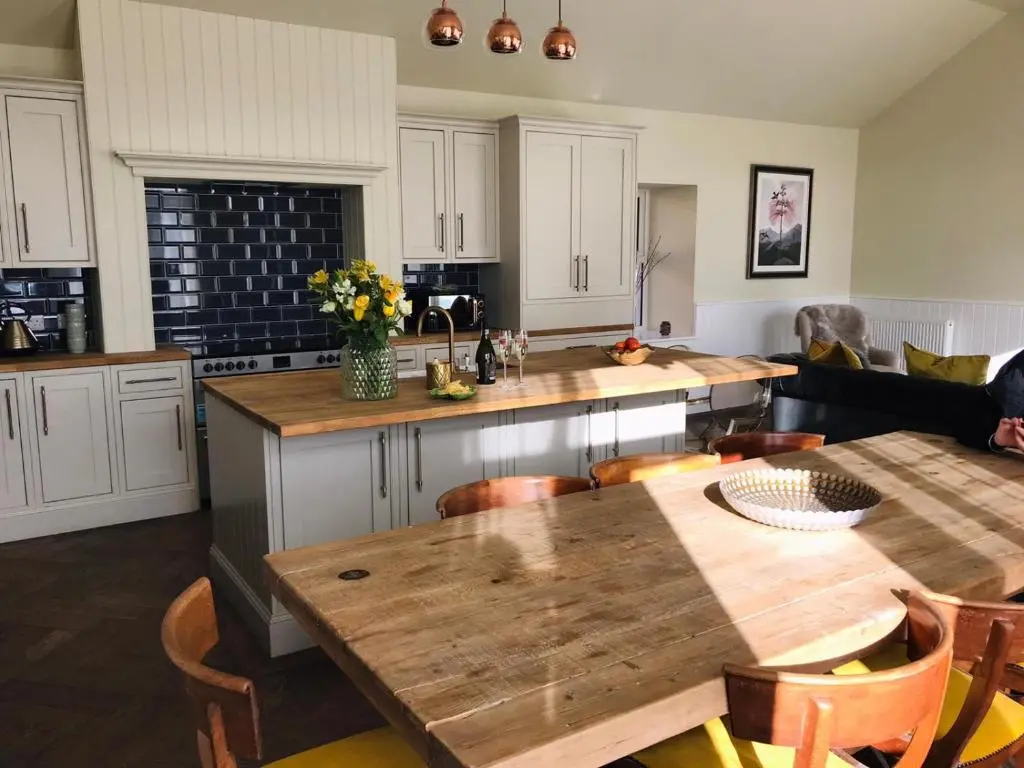 a kitchen with a wooden table and a counter top at Gardeners cottage in Pitlochry