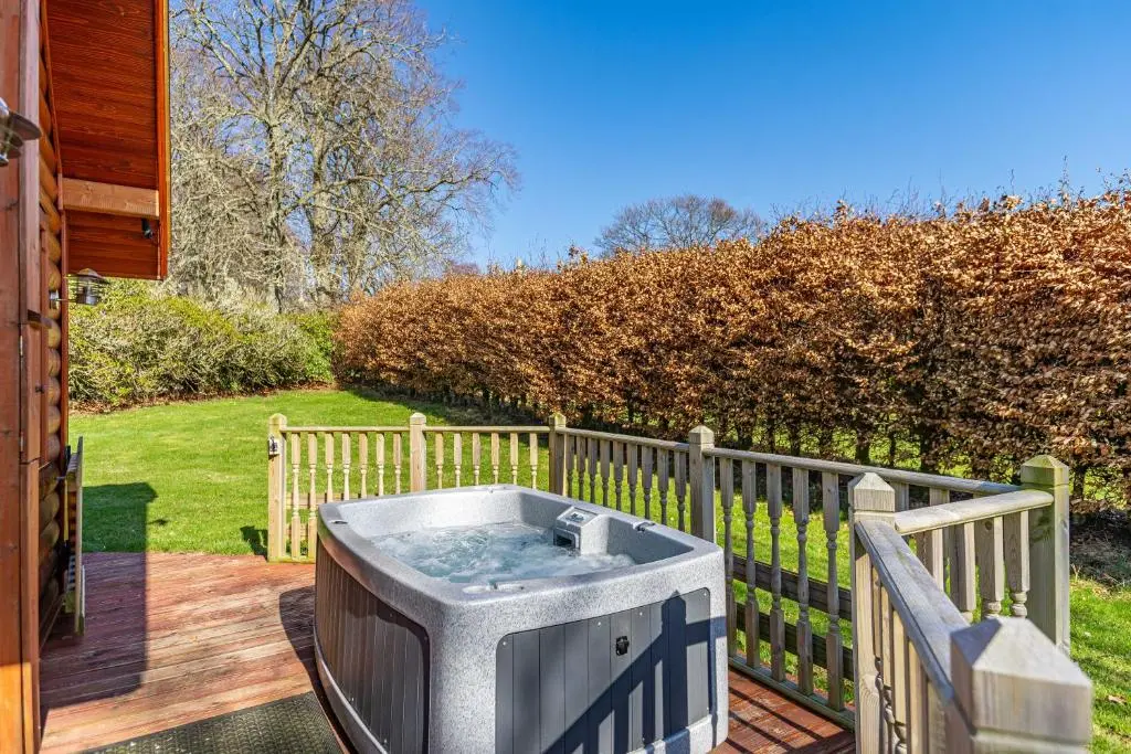 a hot tub sitting on a deck next to a fence at Wildcat Lodge in Cray