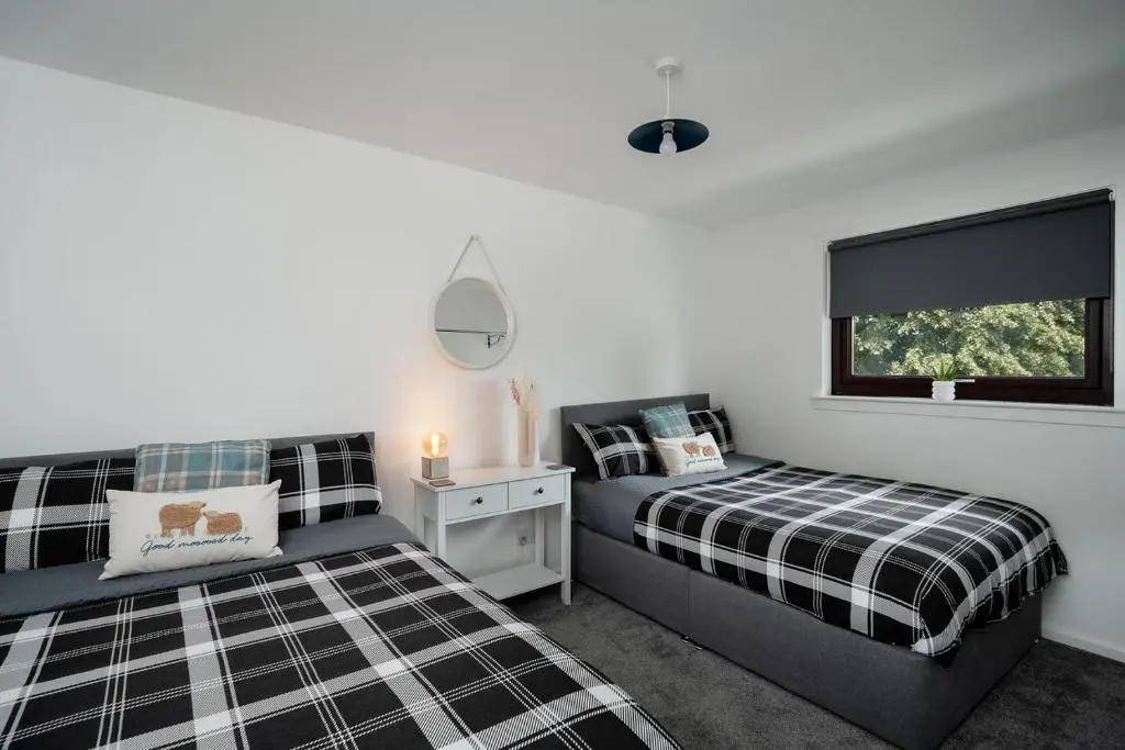 a bedroom with two beds and a window at Ness Riverfront Holiday Home - City Centre in Inverness
