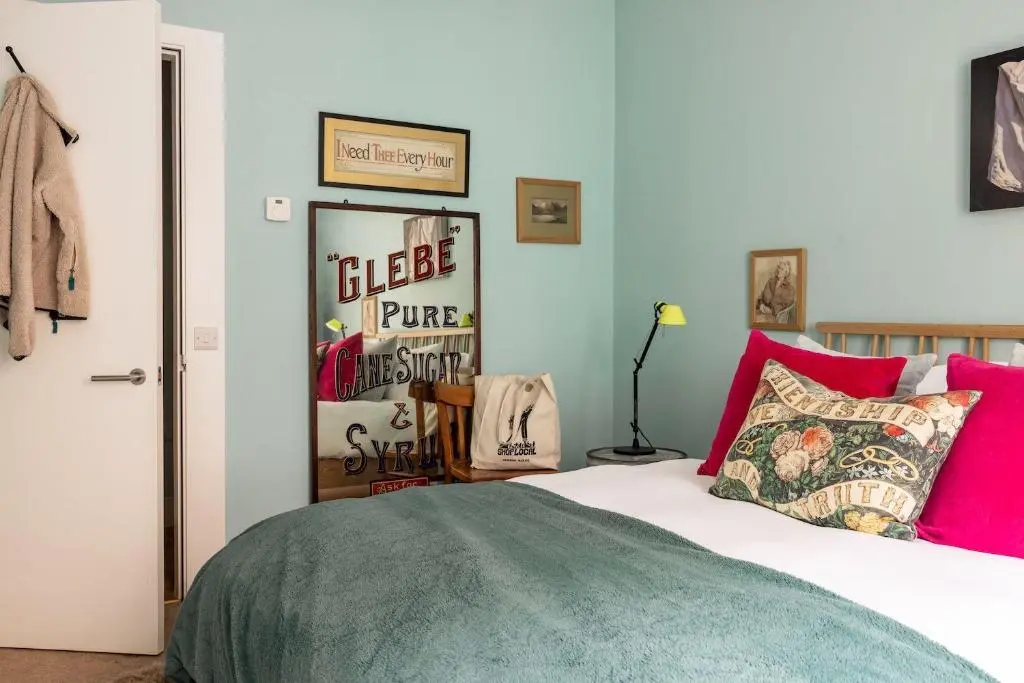 a bedroom with a bed with pink and green at Number 2 Steading Cottage in Banchory