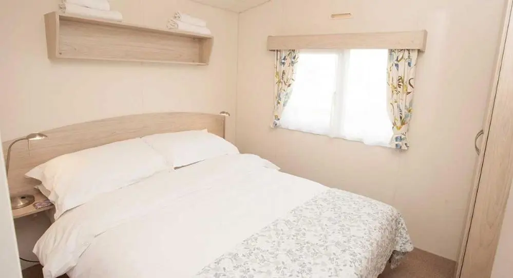a bedroom with a white bed and a window at The Hide near Aviemore in Aviemore