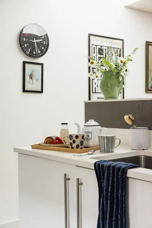 a kitchen with a sink and a clock on the wall at Number 4 Steading Cottage in Banchory