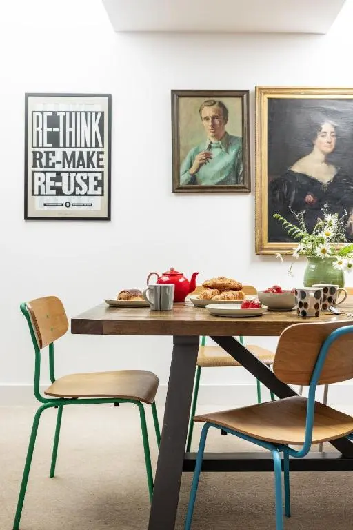 a dining room table with chairs and paintings on the wall at Number 4 Steading Cottage in Banchory