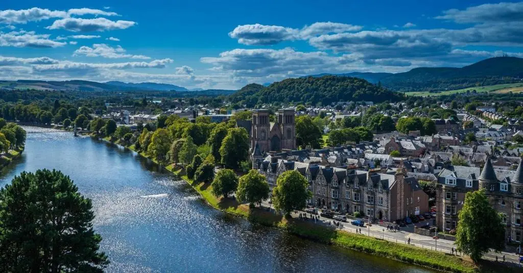 a river in a city with buildings and trees at Apartment at Drummond Crescent in Inverness