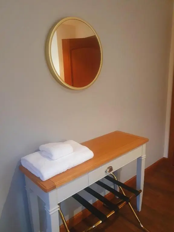 a mirror on a wall above a table with a mirror at Apartment at Drummond Crescent in Inverness
