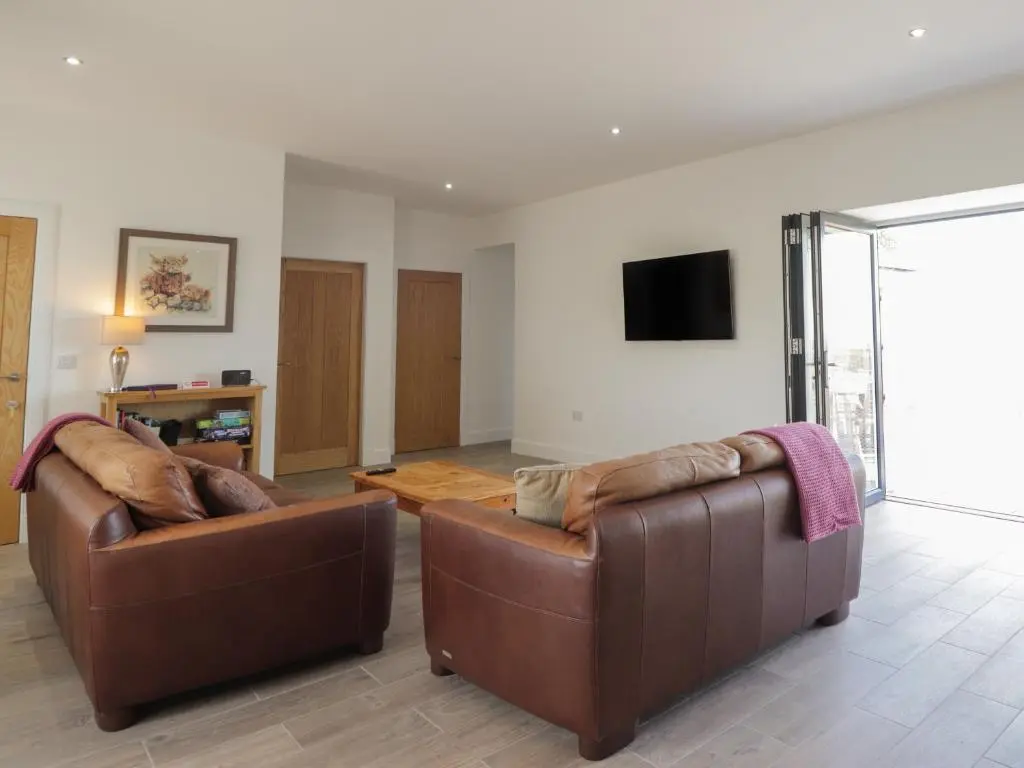 a living room with two brown leather couches at Firthview in Nairn