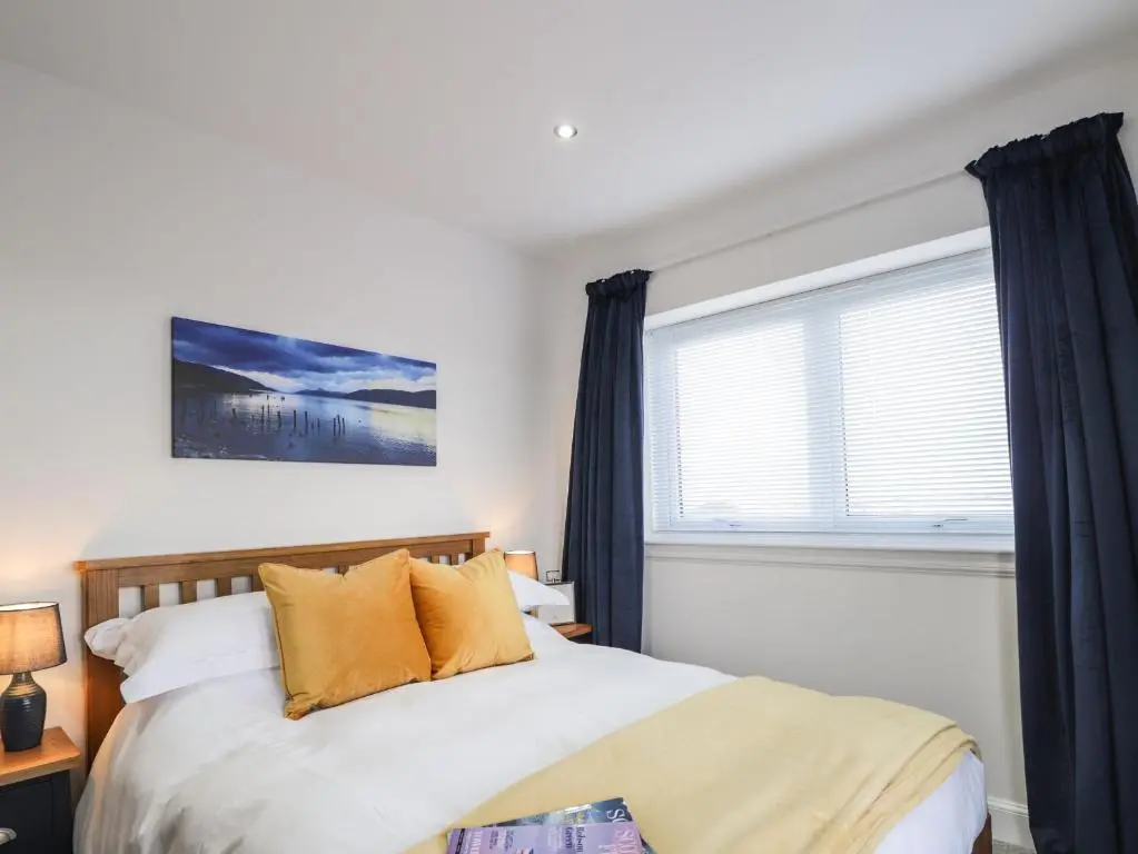 a bedroom with a large bed and a window at Firthview in Nairn