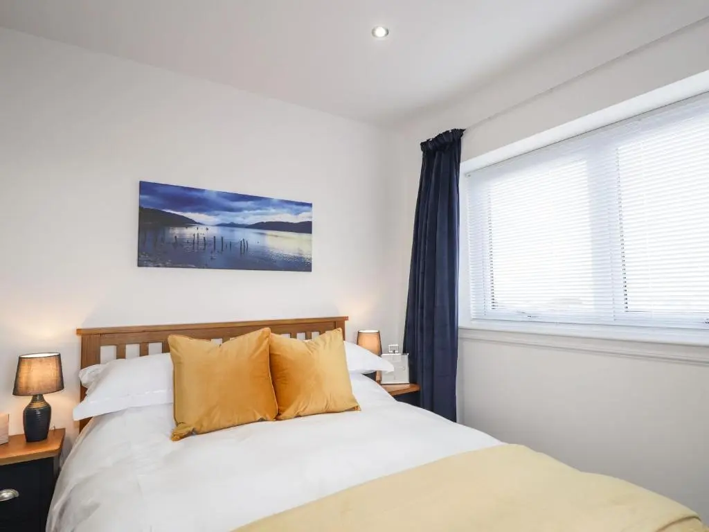 a bedroom with a bed and a window at Firthview in Nairn