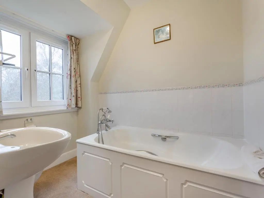 a white bathroom with a tub and a sink at Cruives Lodge in Kiltarlty
