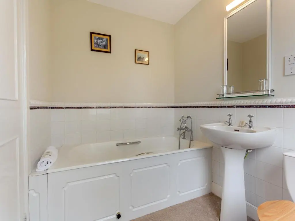 a white bathroom with a sink and a bath tub at Cruives Lodge in Kiltarlty