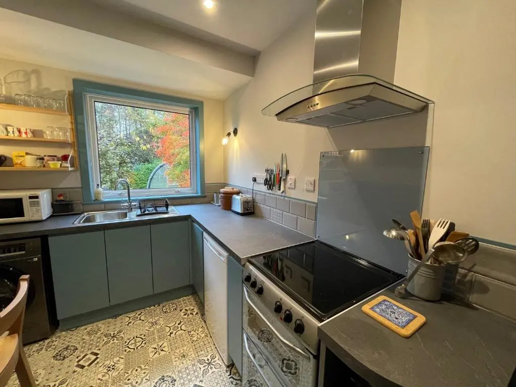 a kitchen with a stove and a sink at One bed cosy Highland cottage near Beauly in Beauly