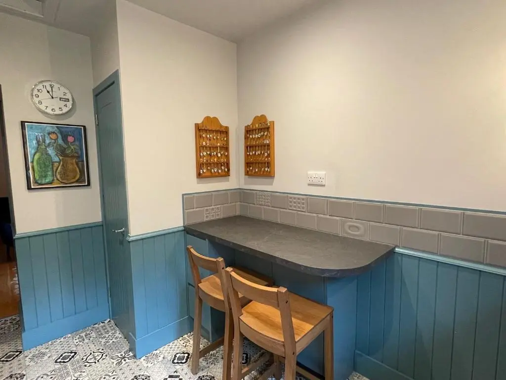 a kitchen with a blue counter and a wooden chair at One bed cosy Highland cottage near Beauly in Beauly