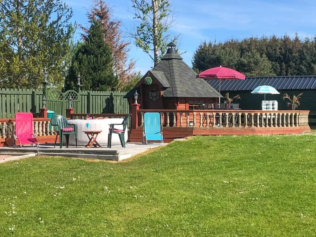 a gazebo with chairs and tables in a yard at Scardroy Alford in Alford