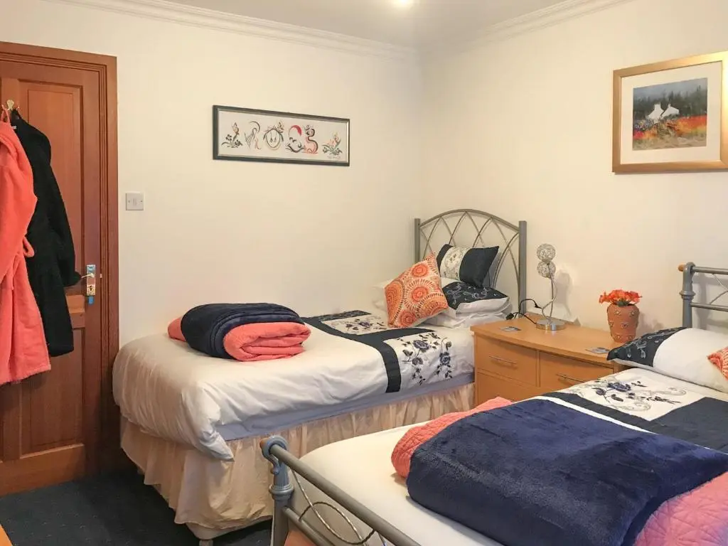 a room with two beds and a dresser and a room at Scardroy Alford in Alford