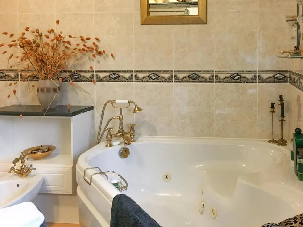 a bathroom with a white tub and a sink at Scardroy Alford in Alford