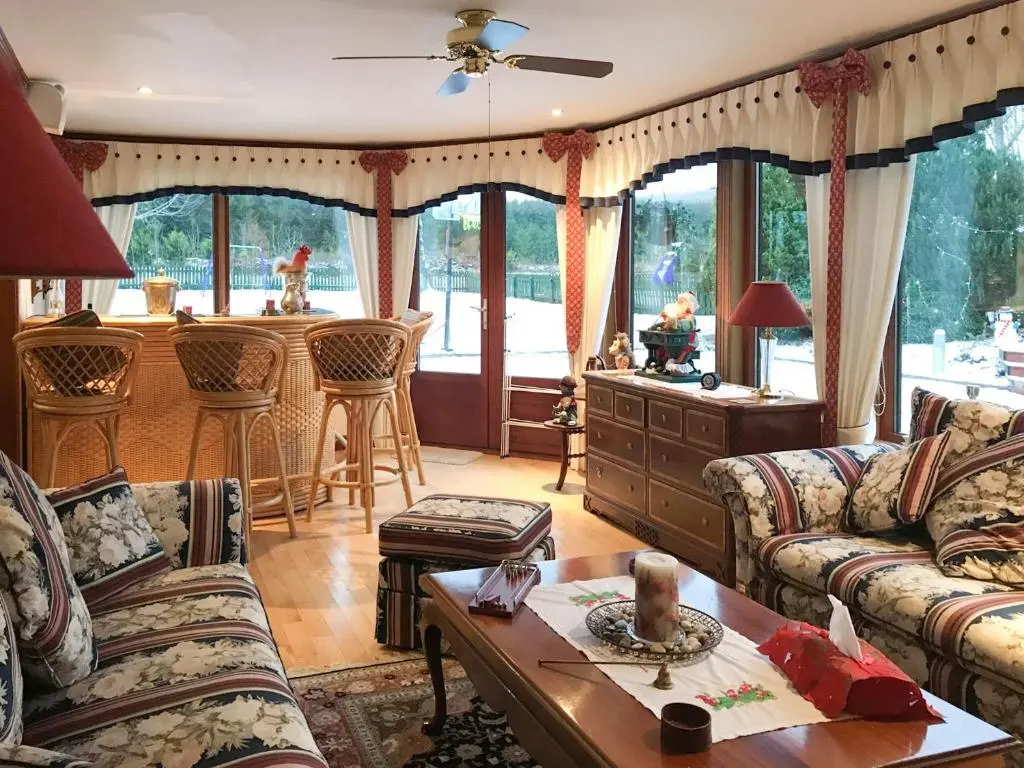 a living room with couches and a kitchen with a bar at Scardroy Alford in Alford