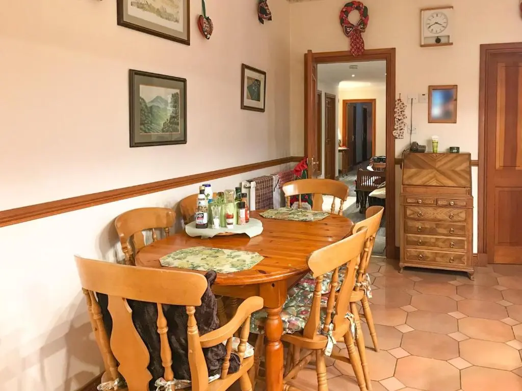a dining room with a wooden table and chairs at Scardroy Alford in Alford