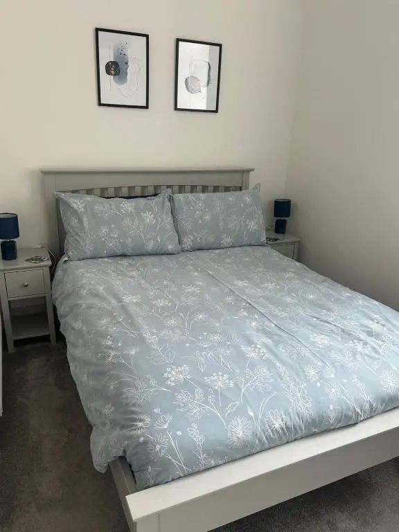 a bedroom with a bed with a blue comforter at Hiltula spacious premium apartment with beautiful views in Inverness