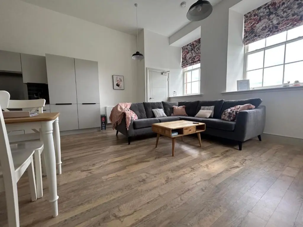 a living room with a couch and a table at Hiltula spacious premium apartment with beautiful views in Inverness