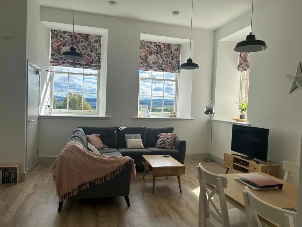 a living room with a couch and a table at Hiltula spacious premium apartment with beautiful views in Inverness