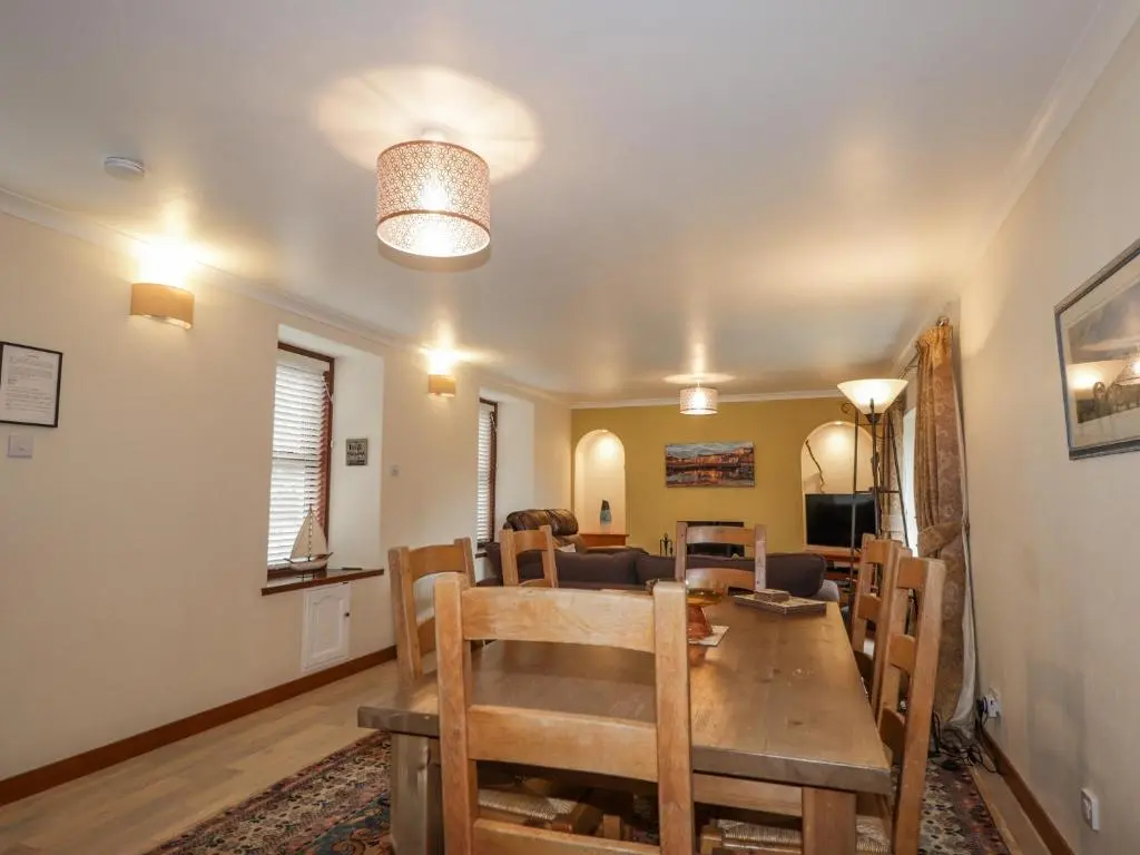 a dining room and living room with a table and chairs at 20 South High Street in Portsoy