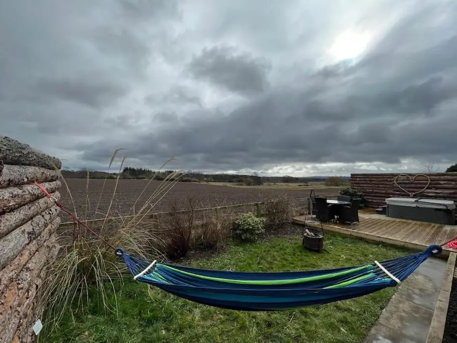 a blue hammock sitting next to a stone wall at Osprey Hide in Forres