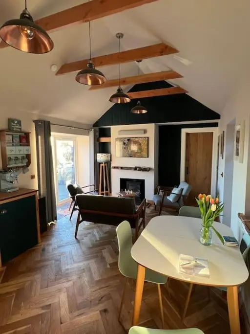 a living room with a table and a dining room at Osprey Hide in Forres