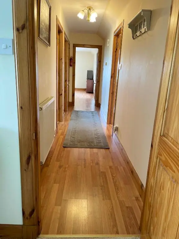 a hallway of a home with wooden floors at Barclay\u2019s But n Ben in Alford